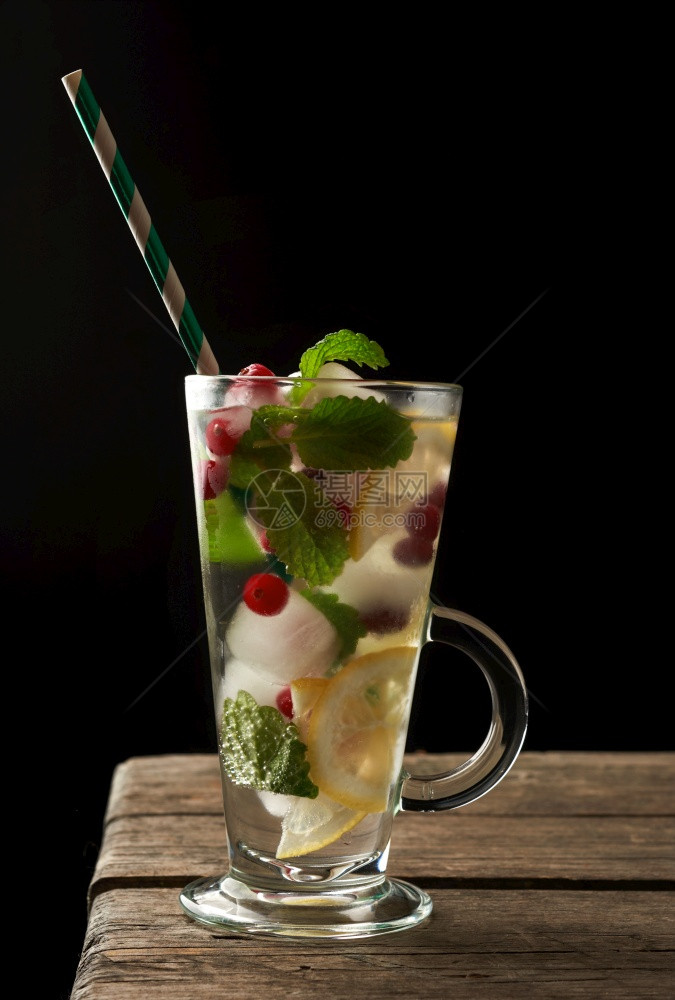 含柠檬汁冰块红莓和纸管的透明杯子柠檬水和冰块红浆果纸管黑色底的清新夏季饮料图片