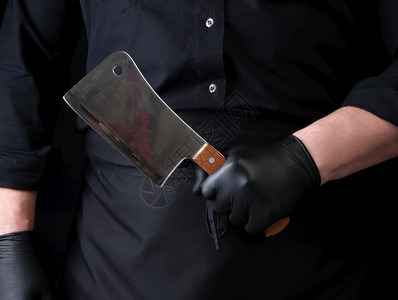 穿黑色制服和乳胶手套的男厨拿着一把大刀子紧闭图片