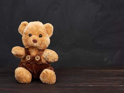 棕褐色泰迪熊坐在棕木桌上坐在空黑粉笔板后面作一个刻字的地方回到学校背景图片
