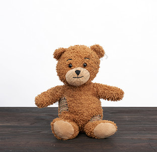 棕色泰迪熊坐在木制桌子上背景图片