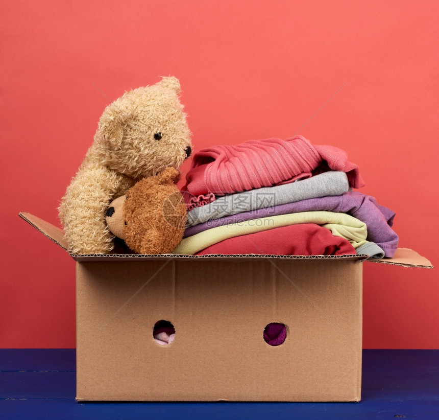 装满衣服和儿童玩具移动概念志愿和帮助的大型棕色纸箱装满衣服和儿童玩具图片