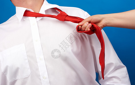 一名身着白衬衫工作场所暴力概念骚扰和支配的成年男子脖上绑着红色丝绸带背景图片