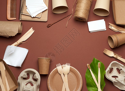 棕色手工艺纸的可支配餐具棕色背景的绿叶从上面看塑料排斥概念零废物复制空间背景图片