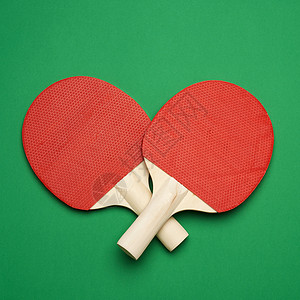 绿色背景的红木桌网球拍一对乒乓运动工具顶视图片