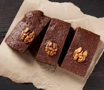 烤巧克力蛋糕棕色纸上有坚果最美景味甜点背景图片