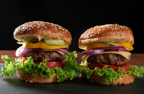 两份美味的汉堡配有炒牛肉番茄生菜和洋葱白面粉包和芝麻种子图片