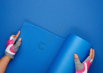 两只手握着运动套的女双展出蓝瑜伽垫子顶层风景图片