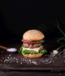 用生菜奶酪洋葱和西红柿在生锈木板上自制汉堡包配有生菜洋葱和番茄图片