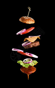 经典芝士汉堡麻面包洋葱环番茄片和黑色背景的多汁烧烤小餐飞食成分背景图片