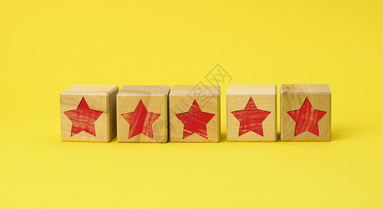 最佳敬业奖5个红星在黄色背景上的木制立方体质量评估概念级最佳服务和高商业估值用户审查背景
