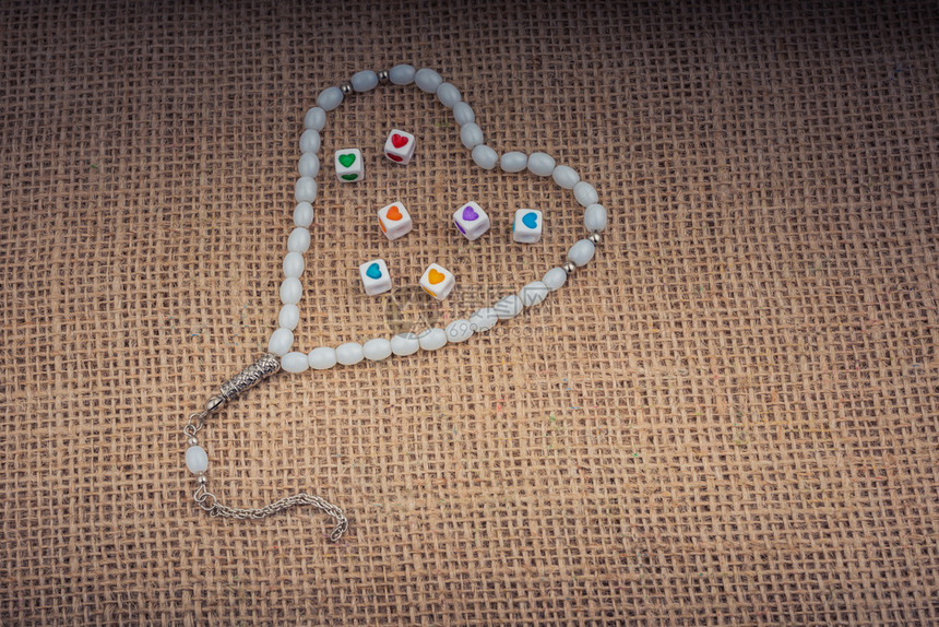 心形立方体手握在一颗祈祷的珠里图片