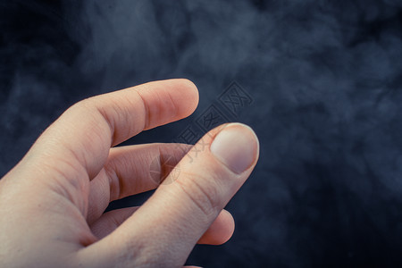 手在黑烟背景上做手势背景图片