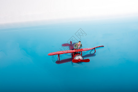 小人偶放在飞机模型上面背景图片