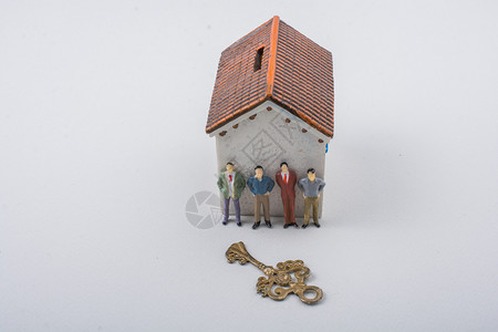 男人的微小雕像和房子前面的钥匙图片