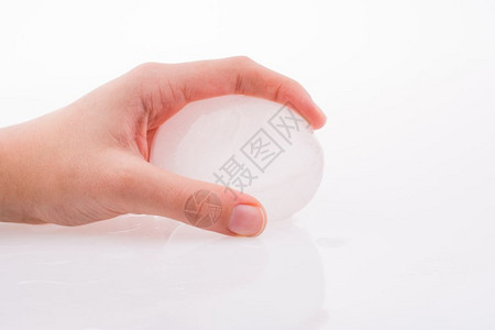 手握着白色背景的冰球图片