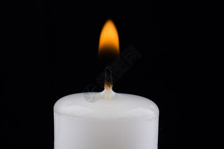 黑色背景上燃烧的白蜡烛图片