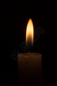 黑色背景上燃烧的白蜡烛图片