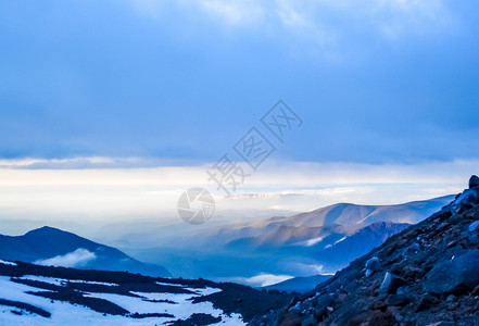 雪山山顶上云层的景色和蓝色的天空图片