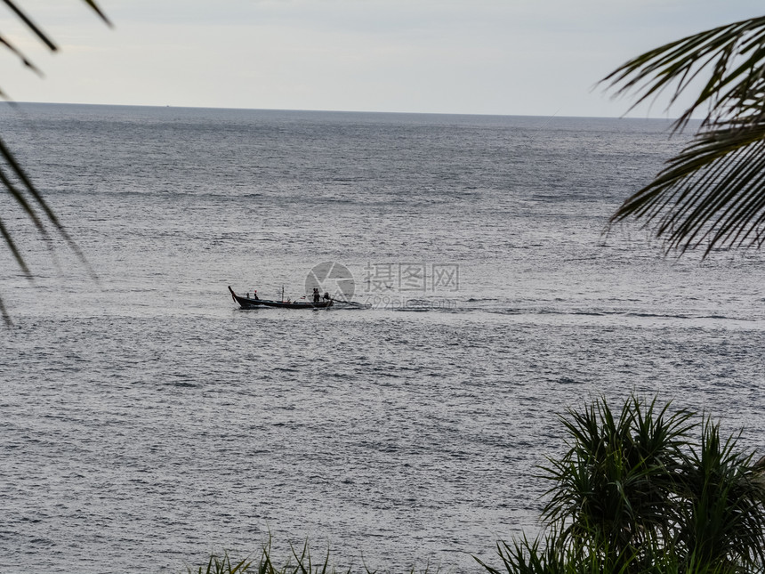 一艘小船在海上航行的渔民图片