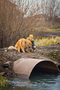 孩子吓坏了大狗看着河水沸腾小孩和狗在大坝上巨的水管97图片