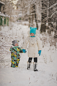 2名幼儿在雪林910处走在雪林中背景图片