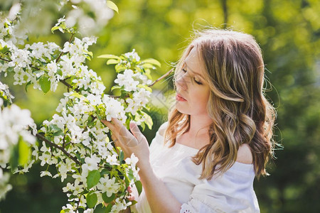 女孩敬佩樱桃园的花朵穿着白裙8235的女孩近身肖像图片