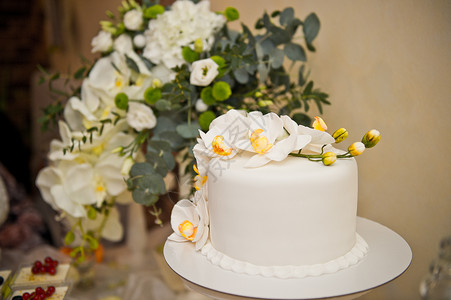 花朵在桌子上盛着甜点和蛋糕图片