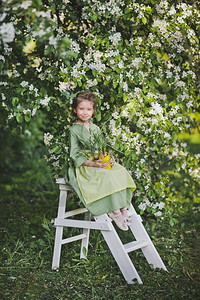 女孩穿着绿色的礼服和围裙在花园背景图片