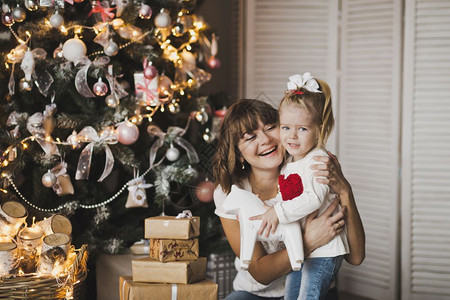 快乐的母亲和女儿在圣诞绿树7250上玩耍背景图片
