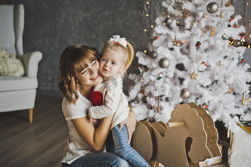 在圣诞树附近拥抱母亲和女儿妈在圣诞节装饰品710上拥抱女儿图片