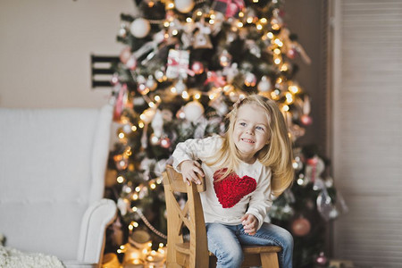 红心女孩坐在树前的衣服上红心女孩在圣诞树7301附近的衣服上图片