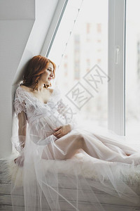 坐在窗台上户的女孩穿着白袍的漂亮女孩坐在窗台上689图片
