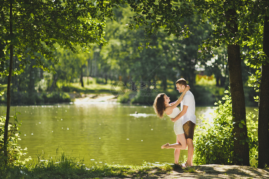 快乐的情侣在湖岸边约会图片