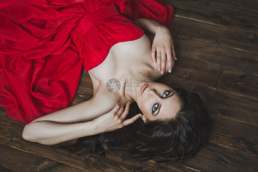 穿红色礼服的女孩躺在地板上图片