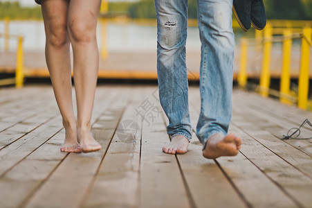 男女双脚在湖码头的足桥上图片