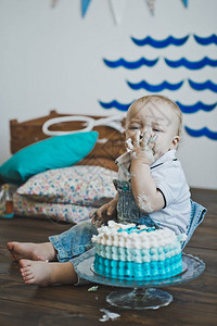 婴儿用手坐着吃蛋糕儿童把的手放在地板上5603图片