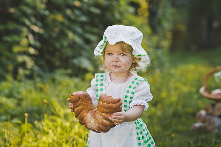 在花园里一个小姑娘在花园里吃新鲜的面包463年在花园里吃新鲜的面包图片