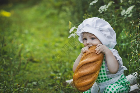男孩在花园吃新鲜的面包在花园470图片