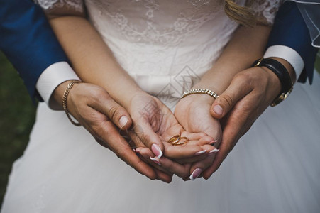新郎用4815环拥抱新娘的手掌背景图片
