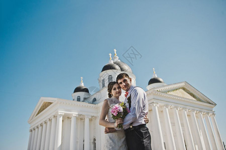 夫妻们站在白柱前丈夫和妻子拥抱着第3796号教堂的背景背景图片