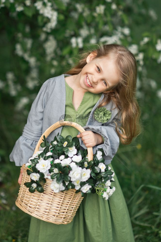 快乐的年轻女孩拿着一篮子鲜花1823年的春天和一篮子花在他手里图片