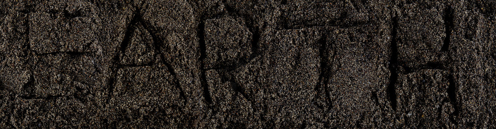 黑暗土壤泥和石块的平面地高的顶部视图与文字地球连接的宏观视图图片