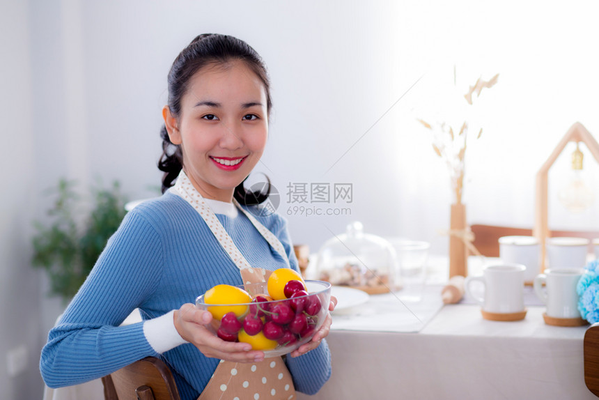漂亮的女人在厨房里笑着拿碗的漂亮女人图片
