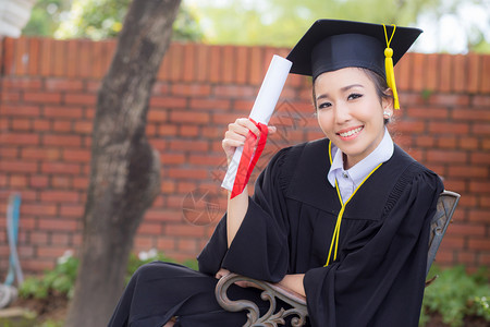 快乐的毕业女学生持有证书祝贺教育成功图片