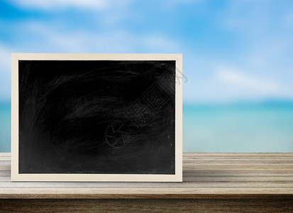 空白黑板带有海滩背景的黑板复制空间桌面上的黑板用于图形应商业工作的黑板可用于显示您的产品图片