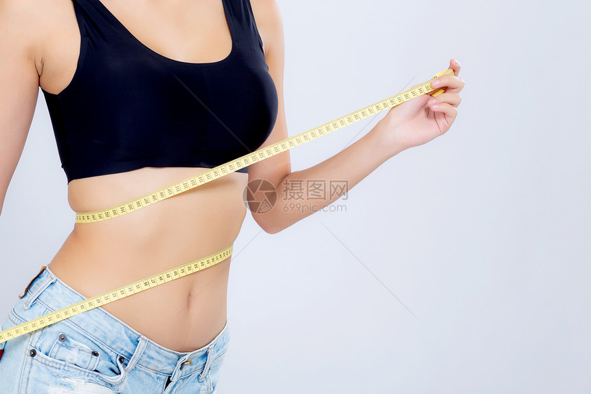 亚洲妇女的饮食和体瘦腰部尺寸与白色背景的体重隔绝女孩用胶带测量健康和概念丧失了纤维素和卡路里图片