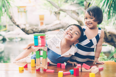 亚洲男孩和笑脸玩木制的块具在桌面上创造和发展享受快乐的儿童学习活动拼图的技能在家桌上玩游戏的创造力教育概念微笑高清图片素材