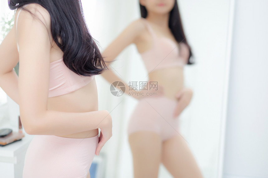 穿着内衣的美丽年轻女生活方式在家里照镜子时肚身材瘦弱内衣美貌的女孩体重减退腹部和腰感完美图片