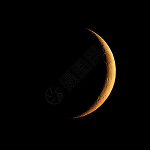 以天文望远镜和日落时的橙色光照耀着新月以望远镜观测到新月图片
