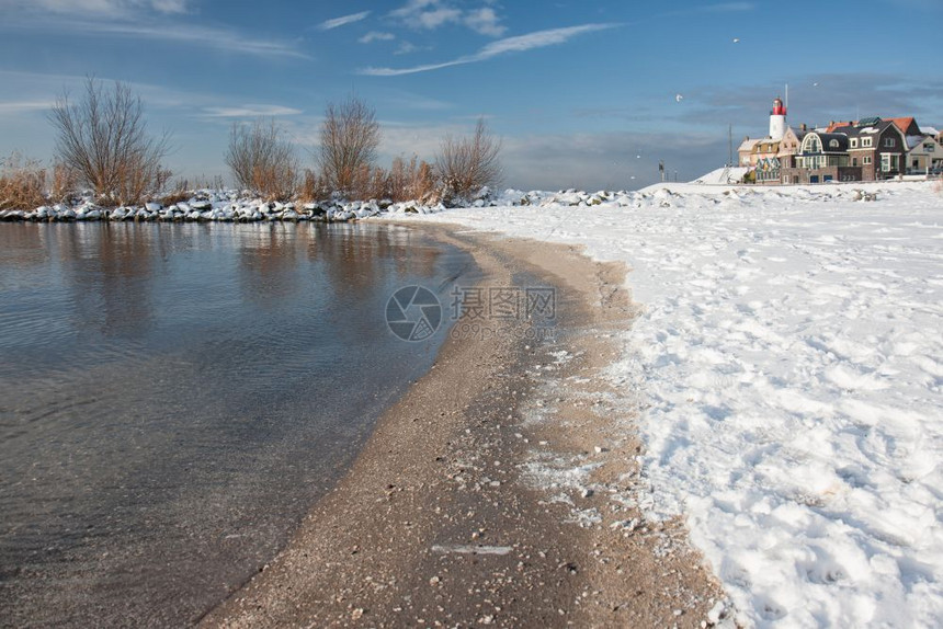 冬季风景荷兰海滩覆盖着雪和鱼村乌尔克的灯塔风景荷兰海滩覆盖着雪和灯塔乌尔克风景图片